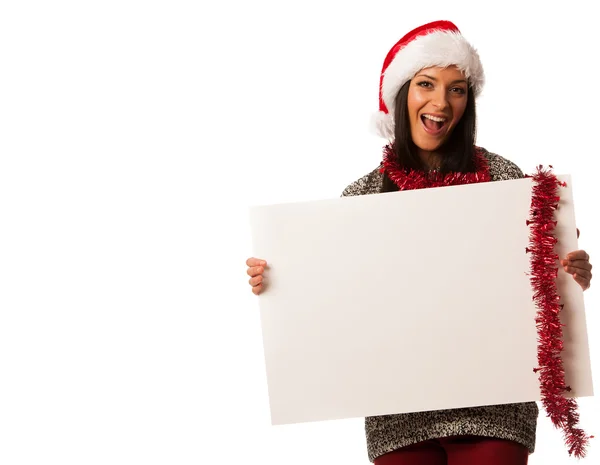 Young woman in santa hat holding blank board for advertisement. — Stock Photo, Image