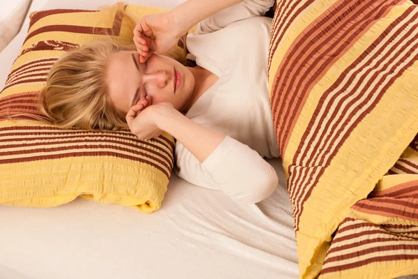 Vrouw liggend in bed, die zich uitstrekt in de ochtend als wakker. — Stockfoto