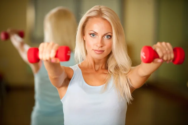 Fitness träning - fit kvinna utbildning med dumbellc i gymmet — Stockfoto