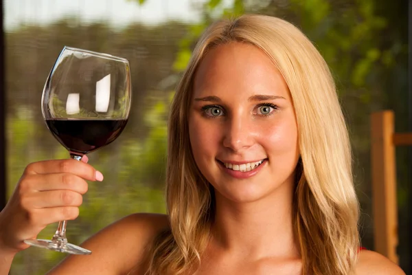 Vacker kvinna dricker rött vin utomhus på en varm sommar afternoo — Stockfoto