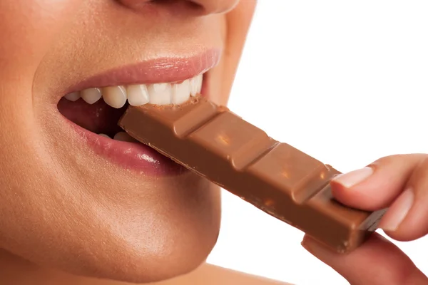 Gyönyörű fiatal nő eszik csokoládé, elszigetelt, felett, fehér backgro — Stock Fotó