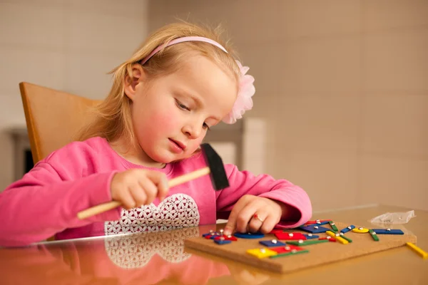 Bonito menina pino apontando blocos em madeira bordo jogar w — Fotografia de Stock