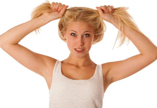 Beautiful young blonde woman holds hair in her hand gesturing ex — Stock Photo, Image