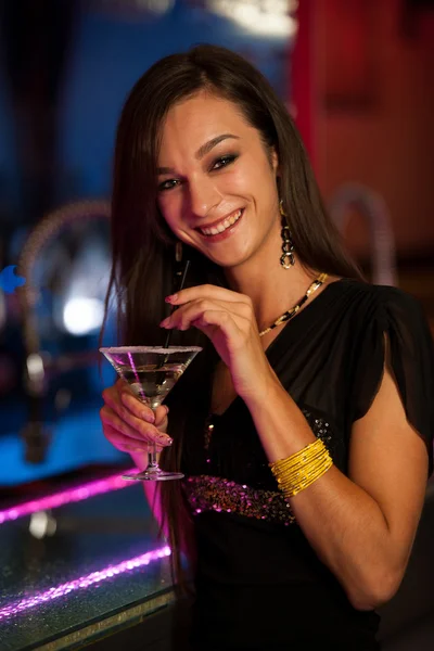 Девушка выпивает коктейль в ночном клубе — стоковое фото