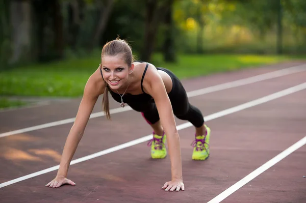 Frau trainiert auf Leichtathletikbahn — Stockfoto