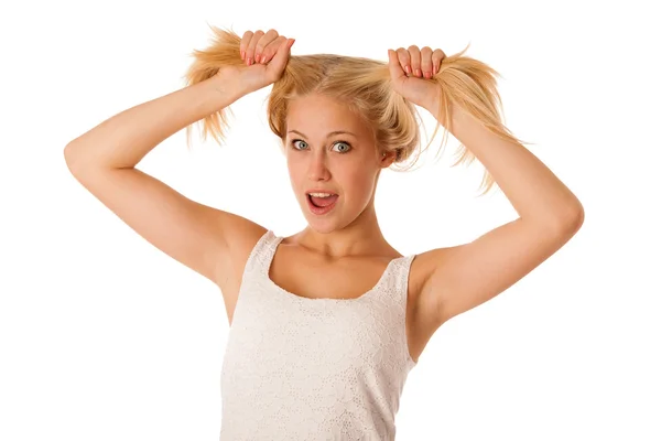 Beautiful young blonde woman holds hair in her hand gesturing ex — Stock Photo, Image