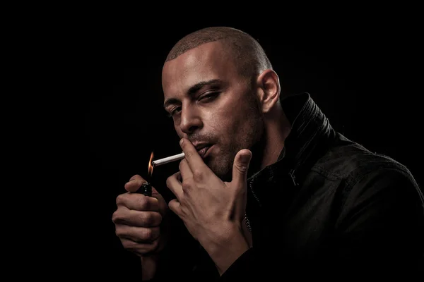 Handsome young man smokes cigarette in darkness - photography of — Stock Photo, Image