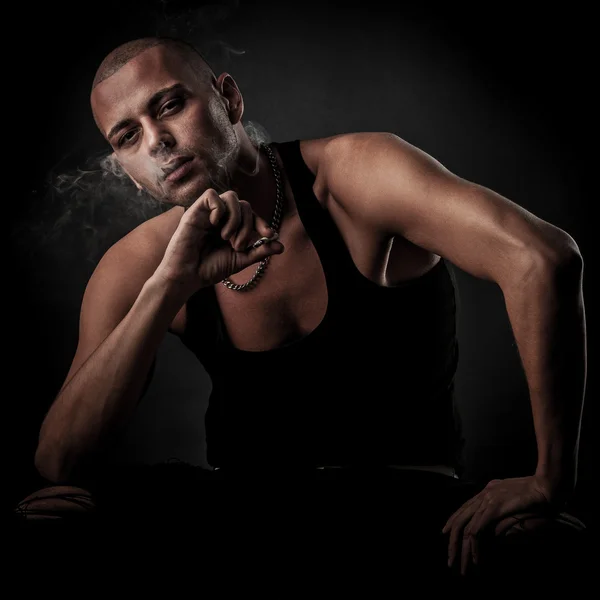 Handsome young man smokes cigarette in darkness - photography of — Stock Photo, Image