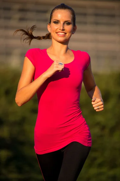 Preety young woman running on a track — Stock Photo, Image