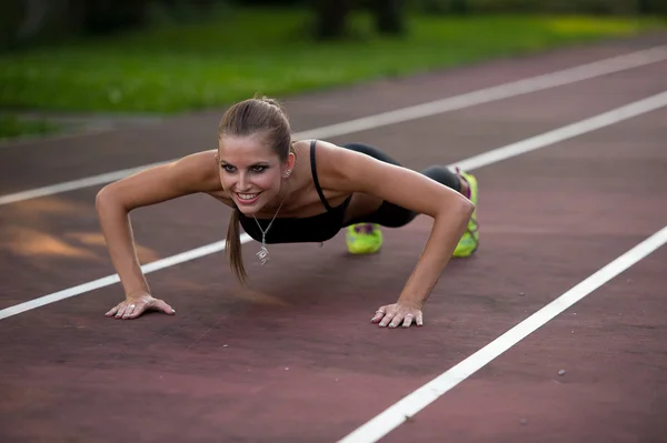 Mujer haciendo ejercicio en pista de atleta —  Fotos de Stock