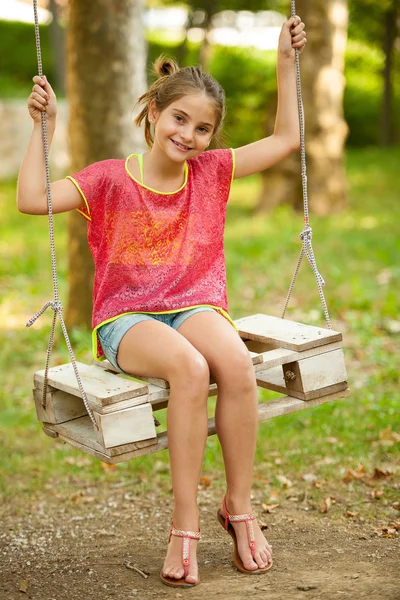 Jovem menina balançando ao ar livre no parque — Fotografia de Stock
