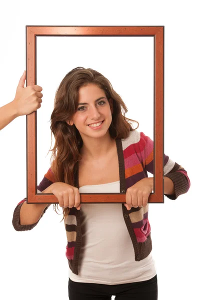 Young teenage girl looks through a frame isolated over white bac — Stock Photo, Image