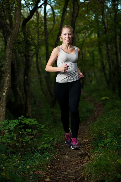 Bella giovane donna corre nella foresta - corridore attivo in esecuzione — Foto Stock