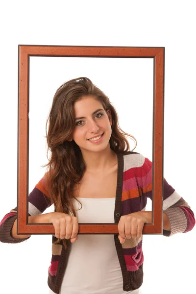 Young teenage girl looks through a frame isolated over white bac — Stock Photo, Image