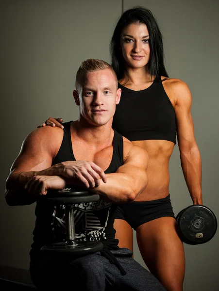 Fitnesspaar - Frau und Mann mit Kurzhanteln im Fitnessstudio — Stockfoto