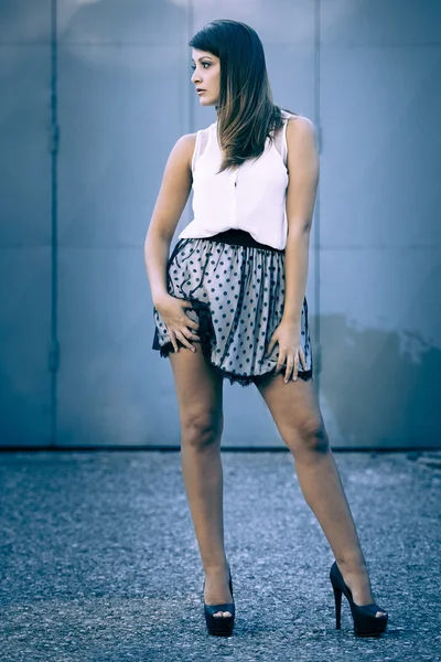 Young beautiful female model standing in front of the old rusty — Stock Photo, Image