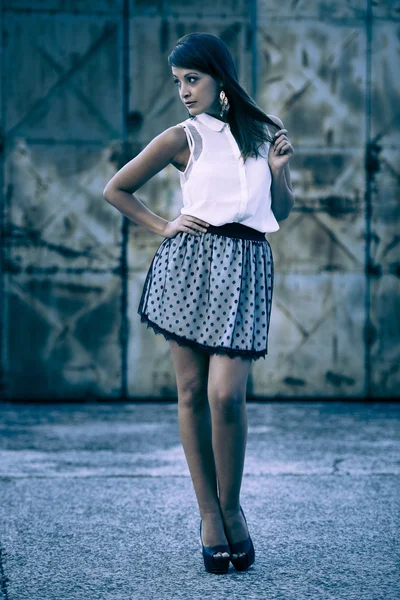 Young beautiful female model standing in front of the old rusty — Stock Photo, Image