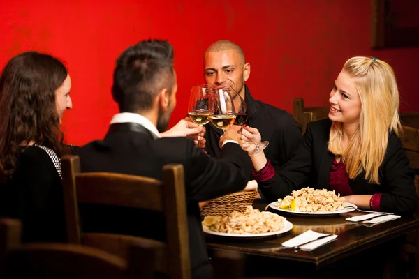 Los jóvenes comen comida de mar en el restaurante y beben vino — Foto de Stock