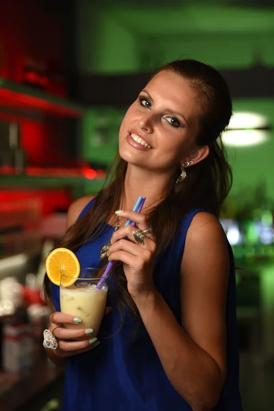 Pretty young brunette woman drinking cocktail in bar — Stock Photo, Image