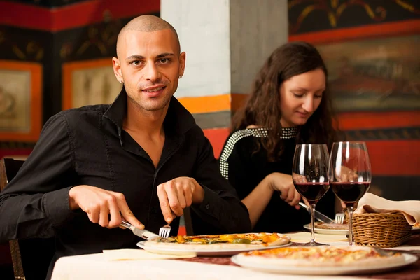 Grupo de jovens come pizza em um restaurante — Fotografia de Stock