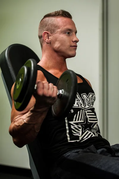 Hnadsome jonge man uit te werken met halters in fitness - powe — Stockfoto