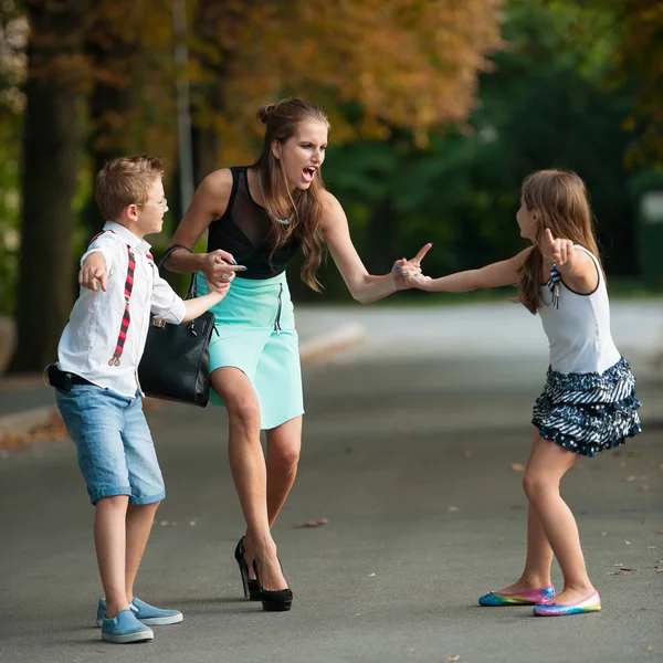 Mutter mit ungezogenem Sohn und Tochter beim Spaziergang im Park — Stockfoto