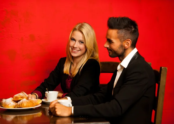 Jovem casal heaving café e croissants no restaurante — Fotografia de Stock