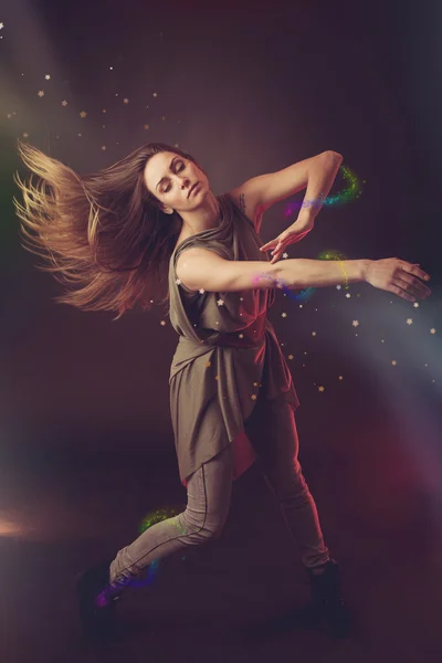 Mooie vrouw danser dansen over donkere achtergrond met lichte r — Stockfoto