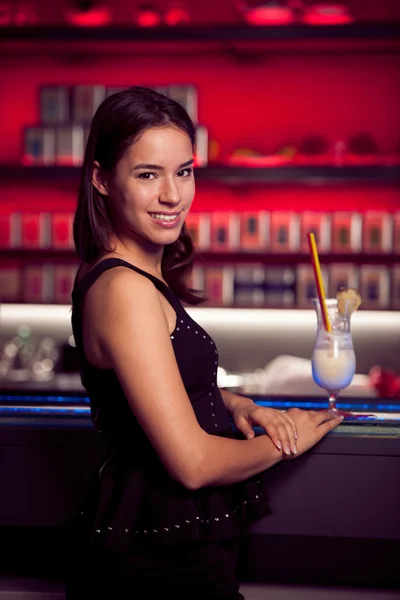 Прецесія молода жінка п'є коктейль в нічному клубі — стокове фото