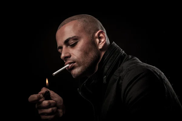 Handsome young man smokes cigarette in darkness - photography of — Stock Photo, Image