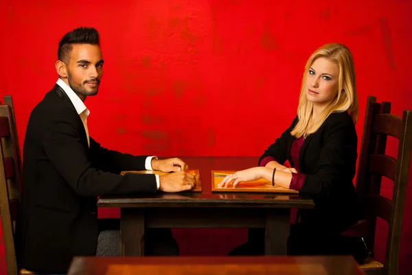 Casal jovem ordenando comida no menu de leitura do restaurante — Fotografia de Stock