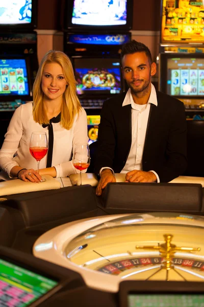 Casal jovem jogando roleta em apostas casino e ganhar — Fotografia de Stock
