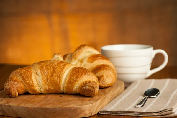 Filiżankę kawy i croisants serwowane śniadanie — Zdjęcie stockowe