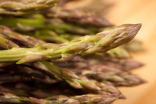 Fresh wild asparagus on a wooden table ready to be cooked — Stock Photo, Image