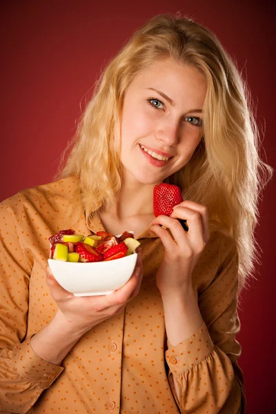 Güzel beyaz sarışın genç kadın lezzetli meyve s tutar — Stok fotoğraf