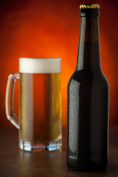 Bottle and glass of beer with waterdrops  served on a stone tabl — Stock Photo, Image