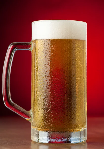 Two glasses of beer on a stone table over red background — Stock Photo, Image