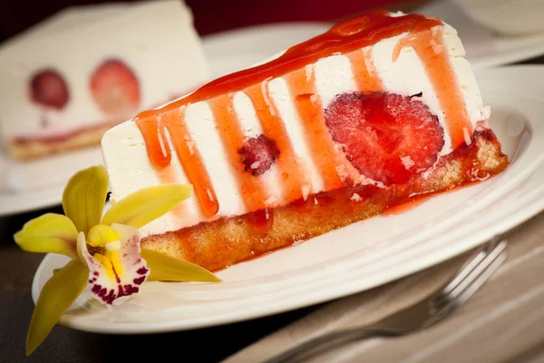 A slice of delicious cheeese cake with strawberries and syrup se — Stock Photo, Image