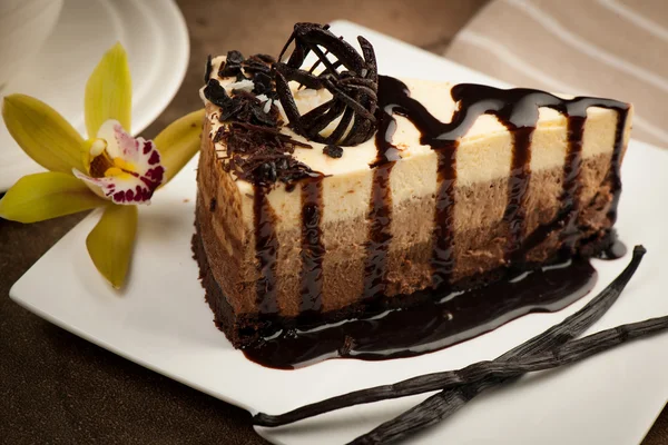 Bolo de chocolate com calda, baunilha e orquídea — Fotografia de Stock