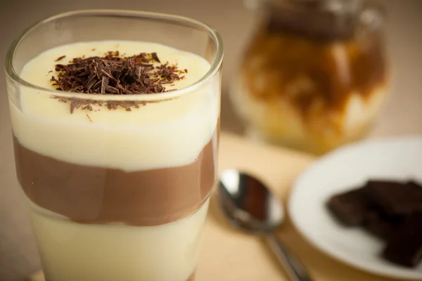 Gemischte Schokolade und Vanillepudding serviert in einem Glas dekoriert lizenzfreie Stockbilder