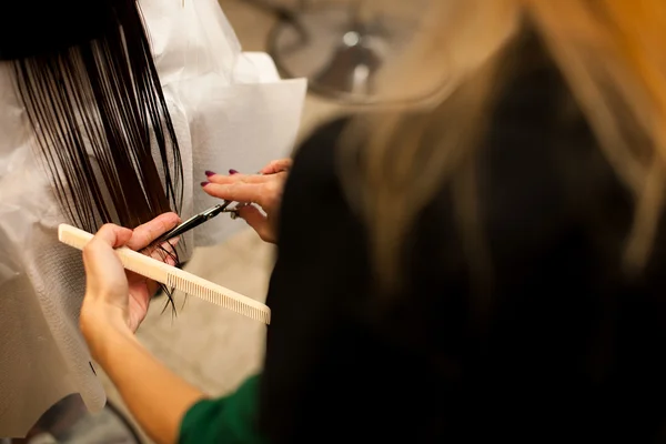 Парикмахер делает уход за волосами для клиента в салоне — стоковое фото