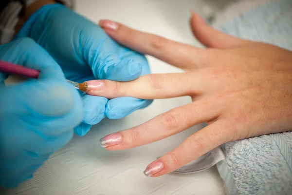 Making hand nails in a professional hand care salon - manicure — Stock Photo, Image