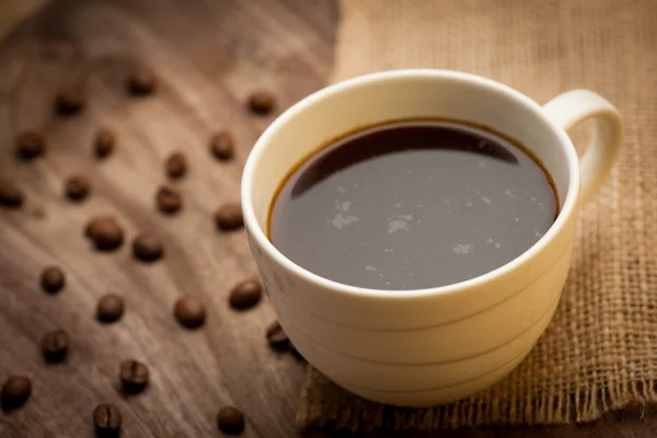 Filiżankę czarnej kawy podawane na drewnianym stole — Zdjęcie stockowe