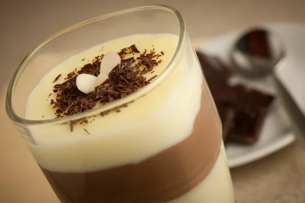 Budino misto di cioccolato e vaniglia servito in un bicchiere decorato Immagine Stock