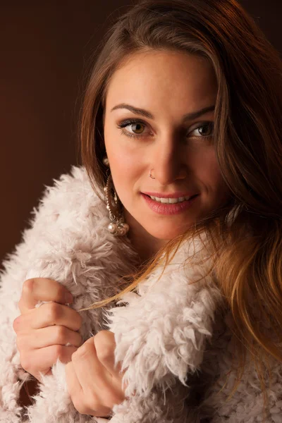 Retrato de uma jovem mulher de cabelos castanhos sorridente com casaco fofo — Fotografia de Stock