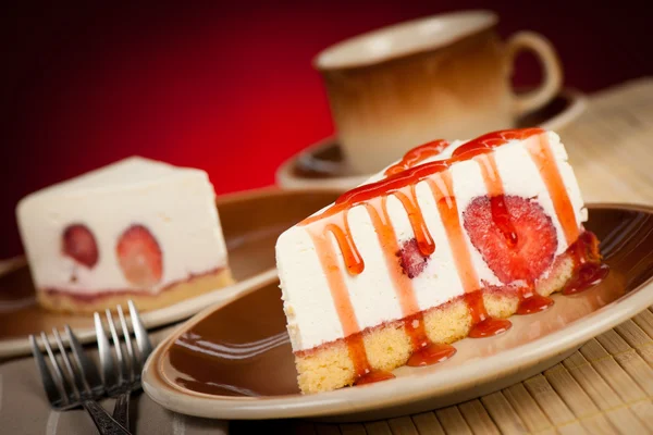 A slice of delicious cheeese cake with strawberries and syrup se — Stock Photo, Image