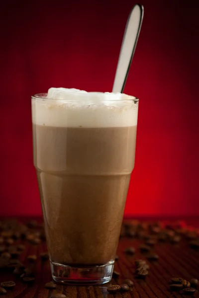 Tasse Cappuccino serviert auf Holztisch mit Kaffeebohnen und r — Stockfoto