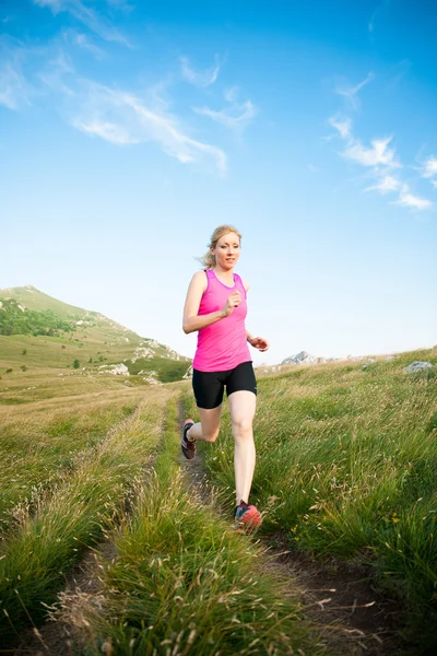 Vacker ung kvinna runns terränglöpning på en mountian bana på — Stockfoto