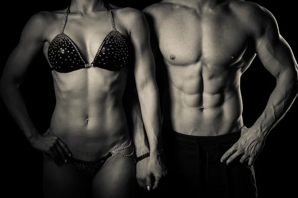 Fitness couple poses in studio - fit man and woman — Stock Photo, Image