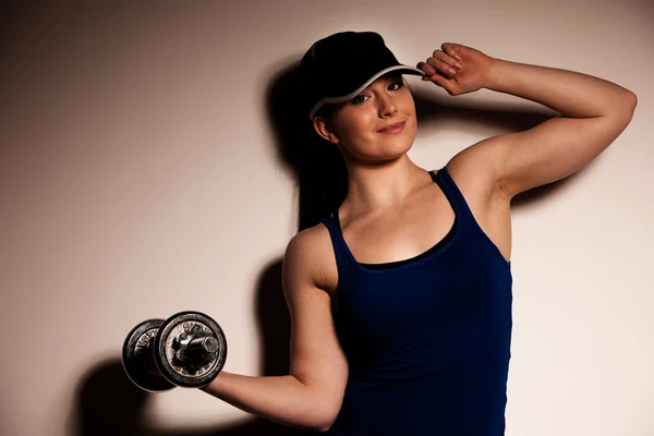 Mooie jonge vrouw uit te werken met dumbels in fitness gym — Stockfoto
